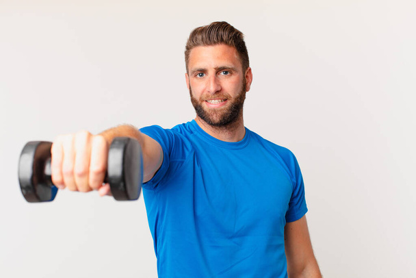 young fitness man lifting a dumbbell - Foto, afbeelding