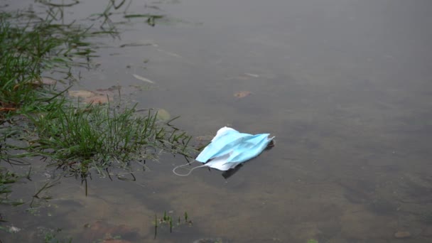 máscara flutua lentamente pelo rio. conceito de poluição ambiental - Filmagem, Vídeo