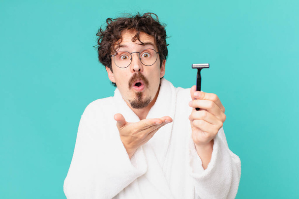 young crazy man shaving his beard with a razor - Φωτογραφία, εικόνα