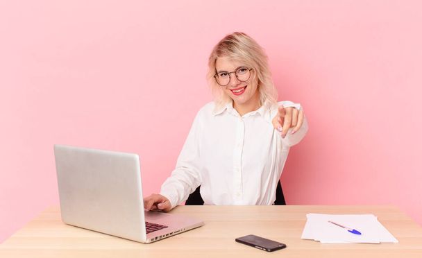 blonde pretty woman young pretty woman pointing at camera choosing you. workspace desk concept - Foto, Bild