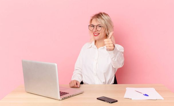 blonde pretty woman young pretty woman feeling proud,smiling positively with thumbs up. workspace desk concept - Foto, afbeelding