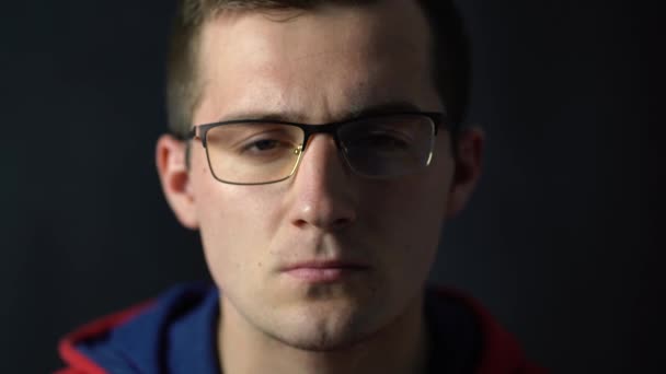 νεαρός άνδρας με γυαλιά κοιτάζοντας την κάμερα - Πλάνα, βίντεο