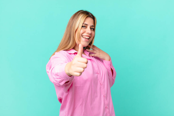 curvy pretty blonde woman feeling proud,smiling positively with thumbs up - Fotoğraf, Görsel
