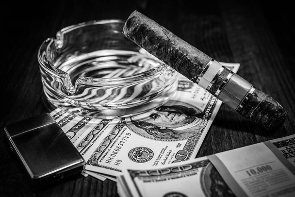 Cuban cigar with glass ashtray on a several dollar bills and als - Foto, immagini