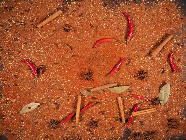 Horní pohled na pikantní červené capsicum skořice a mletý pepř leží na stole. Pikantní pojetí jídla a orientální kuchyně - Fotografie, Obrázek