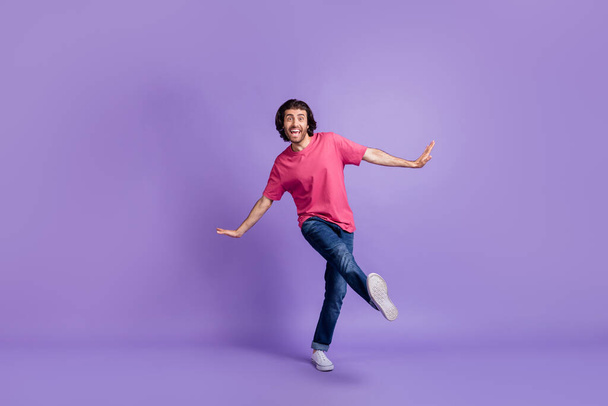 Full length photo of charming cute young guy dressed pink outfit dancing walking isolated purple color background - Fotó, kép