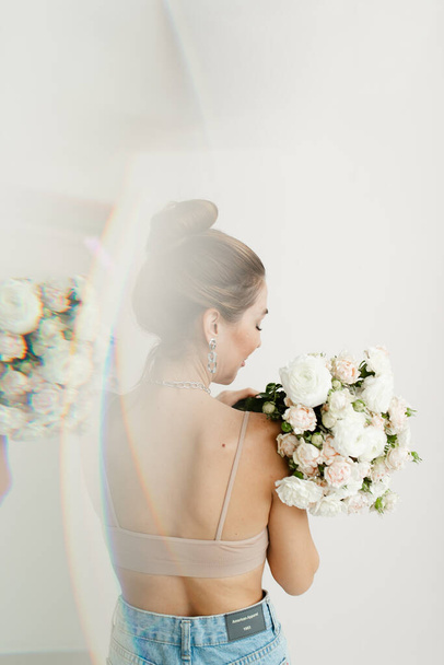 young girl with naked back in bra holding a bouquet of flowers double exposure - Photo, Image