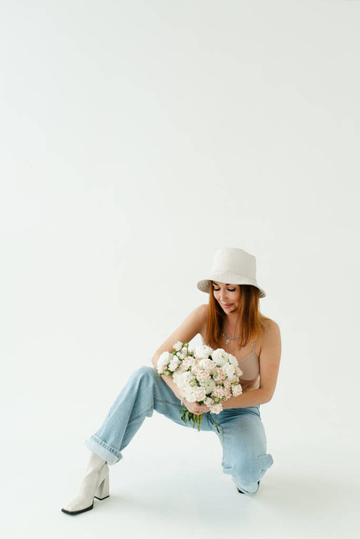 modelo de rodaje en el estudio hermosa chica sobre un fondo sólido en pagama y con un ramo de flores - Foto, Imagen