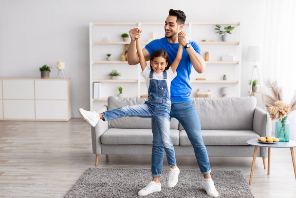 Isä ja tytär tanssivat hauskaa olohuoneessa yhdessä - Valokuva, kuva