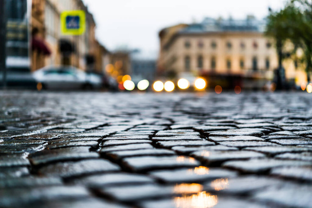 City central square paved with stone after a rain, headlights fr - 写真・画像
