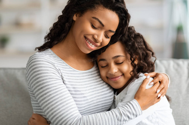 Closeup portrait of hugging african american mother and daughter - Photo, image