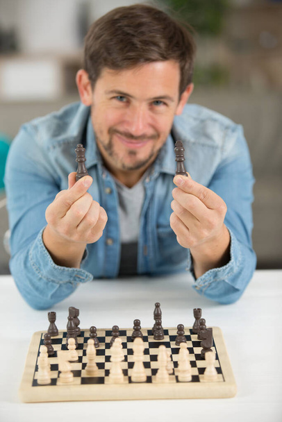 young man holding chess pieces - Φωτογραφία, εικόνα