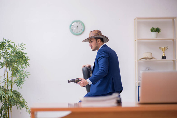 Junger Cowboy-Geschäftsmann arbeitet am Arbeitsplatz - Foto, Bild
