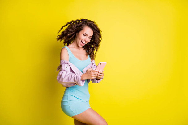 Profile photo of pretty cheerful girl typing blog post comment toothy smile isolated on yellow color background - Foto, immagini