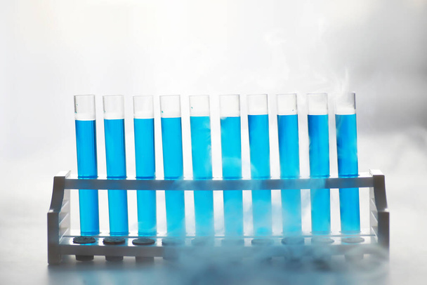 La provetta di vetro trabocca di nuova soluzione liquida che il blu di potassio conduce una reazione di analisi prende varie versioni reagenti usando la fabbricazione chimica del cancro farmaceutico  - Foto, immagini