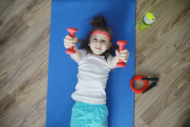 Sport and healthy lifestyle.Child playing sports at home. Yoga mat dumbbell and jump rope. Sports background with home exercises concept. - Zdjęcie, obraz