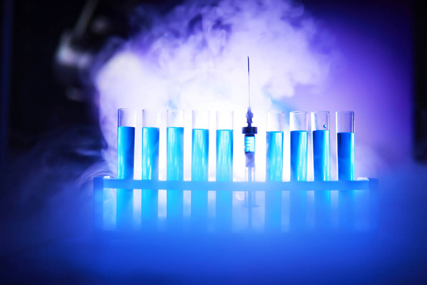 Tubo de ensayo de vidrio desborda nueva solución líquida azul de potasio lleva a cabo una reacción de análisis toma varias versiones reactivos utilizando productos químicos farmacéuticos fabricación de cáncer  - Foto, imagen
