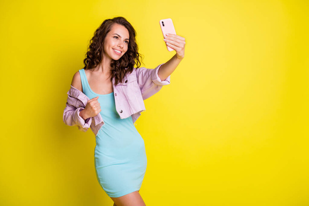 Photo of happy smiling charming pretty young woman talking selfie on cellphone isolated on yellow color background - Zdjęcie, obraz