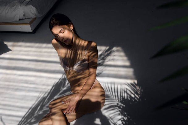 girl with a beautiful figure in lingerie enjoys the sun. Young female model enjoying sunny morning - Foto, Imagen