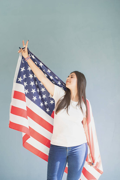 hermosa joven con bandera americana sobre fondo azul - Foto, imagen
