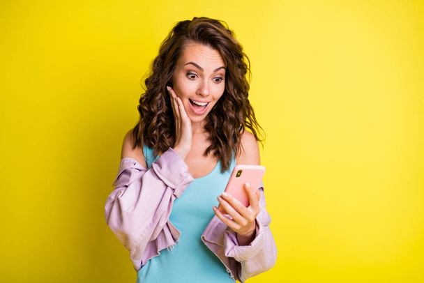 Photo of astonished lady arm on cheek open mouth look phone new blog subscribe isolated on yellow color background - Фото, зображення