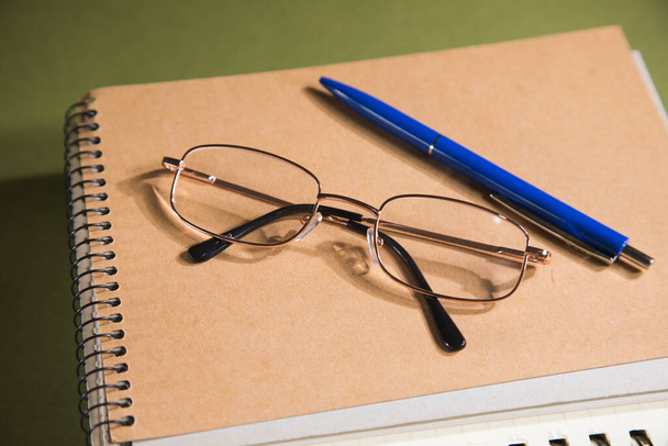 Brille auf Notebooks auf grünem Tisch - Foto, Bild