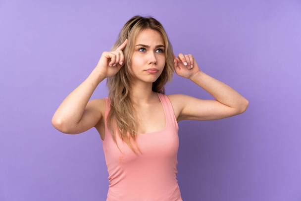 Teenager Russian girl isolated on purple background having doubts and thinking - Photo, Image