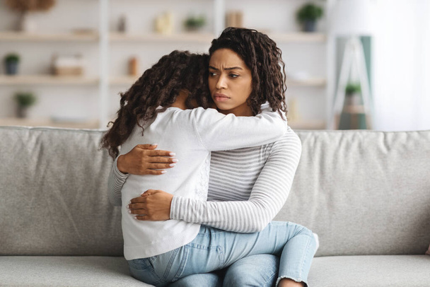 Депрессивная черная мать обнимает свою дочь, крупным планом - Фото, изображение