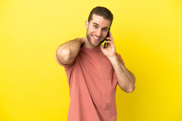 Handsome blonde man using mobile phone over isolated background laughing - Photo, Image