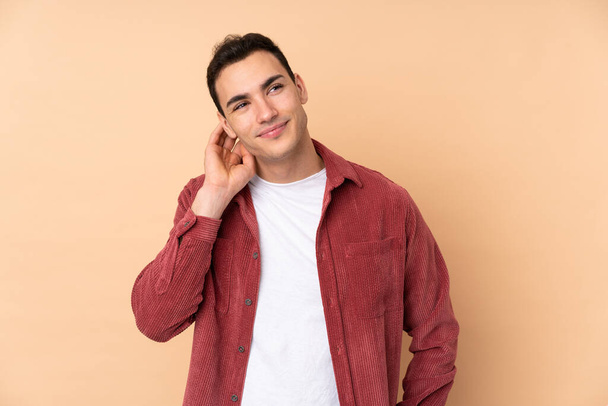 Young caucasian handsome man isolated on beige background thinking an idea - Photo, Image