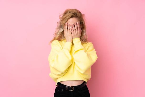 Young blonde woman wearing a sweatshirt isolated on pink background with tired and sick expression - Valokuva, kuva
