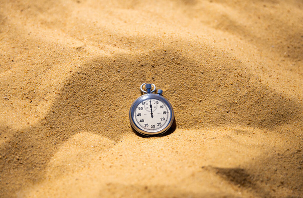 Stopwatch feküdt a sárga homokon, strandröplabda versenyek. Időbeosztás és üzemidő - Fotó, kép