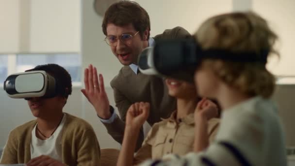 Uczniowie w okularach VR gry. Nauczyciel uczy dzieci korzystać z gadżetów - Materiał filmowy, wideo