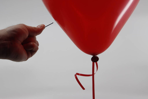 Needle close to a red balloon - Foto, imagen