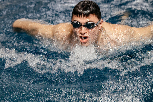 Profi úszó versenyez egy fedett uszodai versenyen. A versenyek koncepciója és a sport motivációja - Fotó, kép