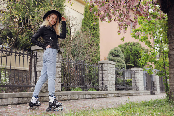 Young woman roller skating on spring day - Фото, изображение