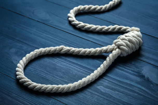 Rope noose with knot on blue wooden table, closeup - Foto, afbeelding