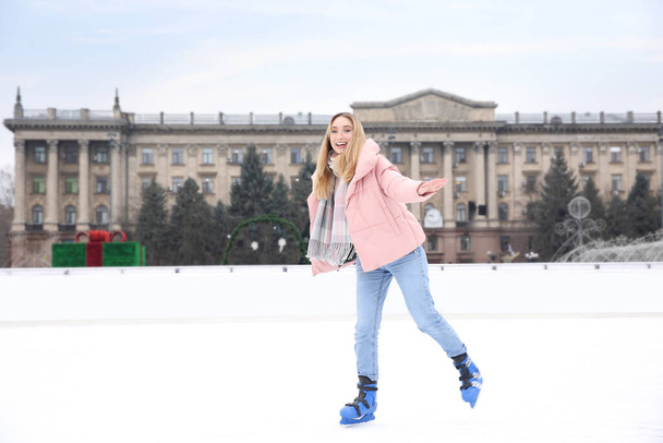 Happy woman skating along ice rink outdoors - Фото, изображение