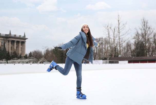 Happy woman skating along ice rink outdoors - Photo, Image