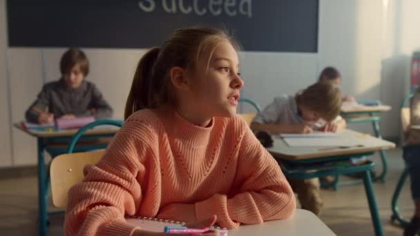 Nachdenkliche Schüler sitzen an der Schulbank. Lächelndes Mädchen beantwortet Fragen - Filmmaterial, Video