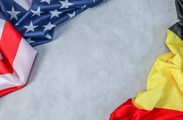 Прапори США і Бельгії лежать на стороні цементного фону з простором для тексту посередині, вигляд зверху зблизька.. - Фото, зображення