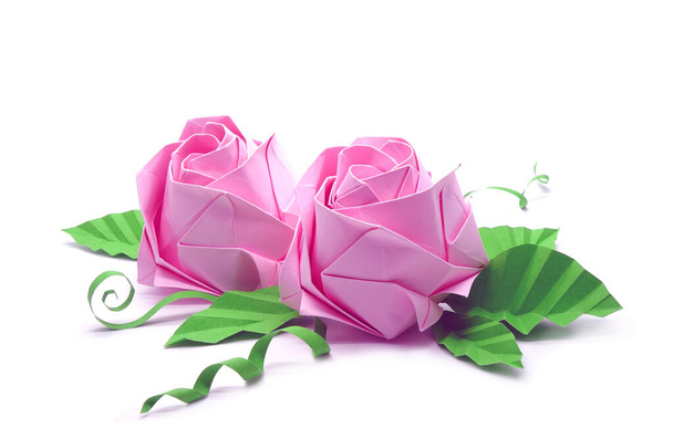 Ροζ τριαντάφυλλα Origami για διακοπές Ημέρα του Αγίου Βαλεντίνου, έννοιες αγάπης. Απομονωμένο σε λευκό φόντο με αντιγραφικό χώρο. - Φωτογραφία, εικόνα