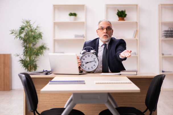 Old male employer in time management concept - Photo, Image