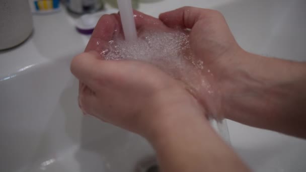 Man put his hands under running water from tap, water saving concept - Footage, Video