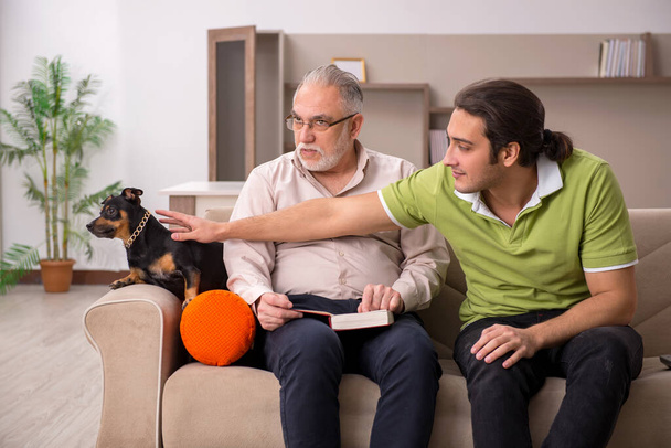 Two men with dog at home - Photo, image