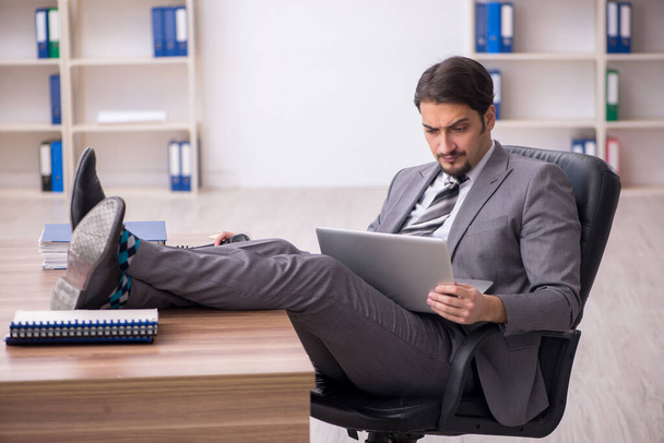 Jeune homme attrayant assis sur le lieu de travail - Photo, image