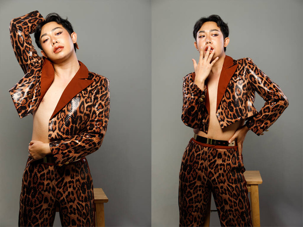 ハーフボディ20代アジアLGBTQIA+ゲイ男性黒髪はブレザー虎のパターンドレスを身に着けているの肖像画。男性doファッションポーズ半分体上のグレーの背景孤立 - 写真・画像