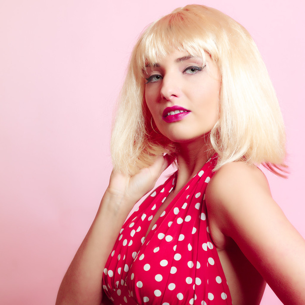 Portrait beautiful pinup girl in blond wig retro red dress. Vintage. - Фото, изображение