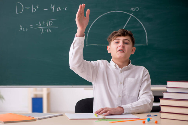 Schoolboy studying geometry in front of blackboard - Photo, Image