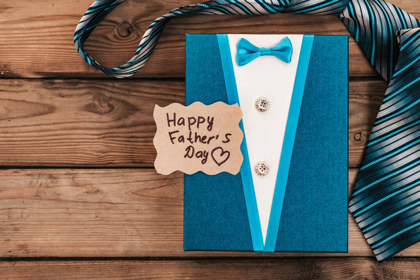 Happy Fathers Day gift blue box with tie on a rustic wood background. - Photo, image